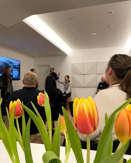 Nahaufnahme eines Tulpenstrauß. Im Hintergrund die Meetup Gruppe.